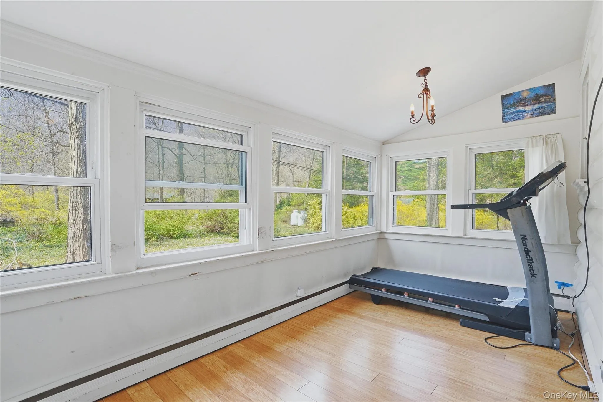 This room features numerous windows, providing ample natural light and views of the surrounding trees This room features numerous windows, providing ample natural light and views of the surrounding trees