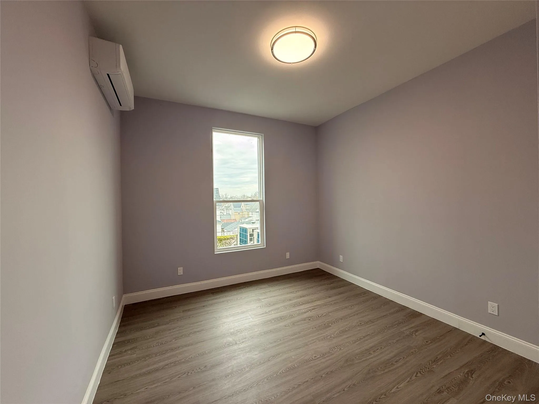 Bedroom #3 featuring wood finished floors and a mini split for heating / cooling Bedroom #3 featuring wood finished floors and a mini split for heating / cooling