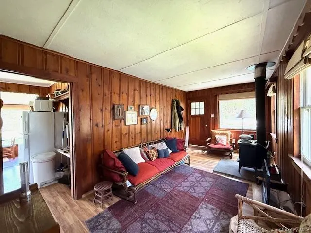 flooring, a wood stove, and wooden walls flooring, a wood stove, and wooden walls
