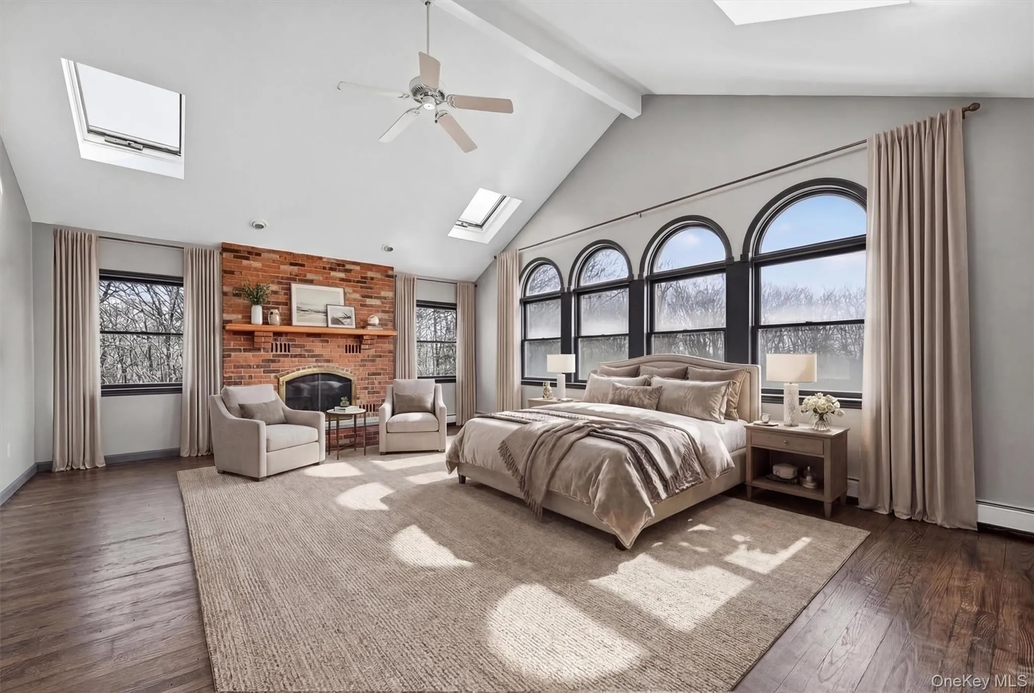 Spacious primary bedroom with Palladian windows, skylights and a brick fireplaceVirtually Staged Spacious primary bedroom with Palladian windows, skylights and a brick fireplaceVirtually Staged