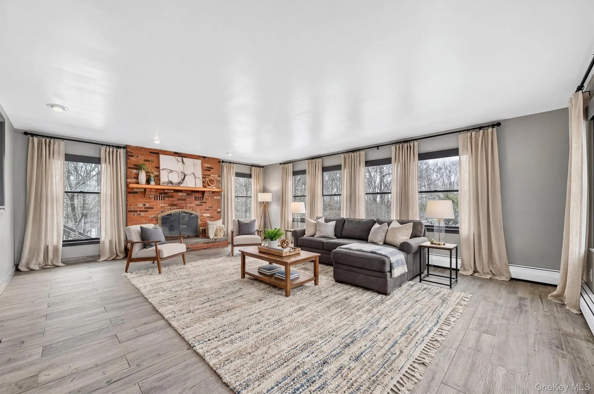 Large and warm sunken family room with plenty of windows and a brick fireplaceVirtually Staged Large and warm sunken family room with plenty of windows and a brick fireplaceVirtually Staged