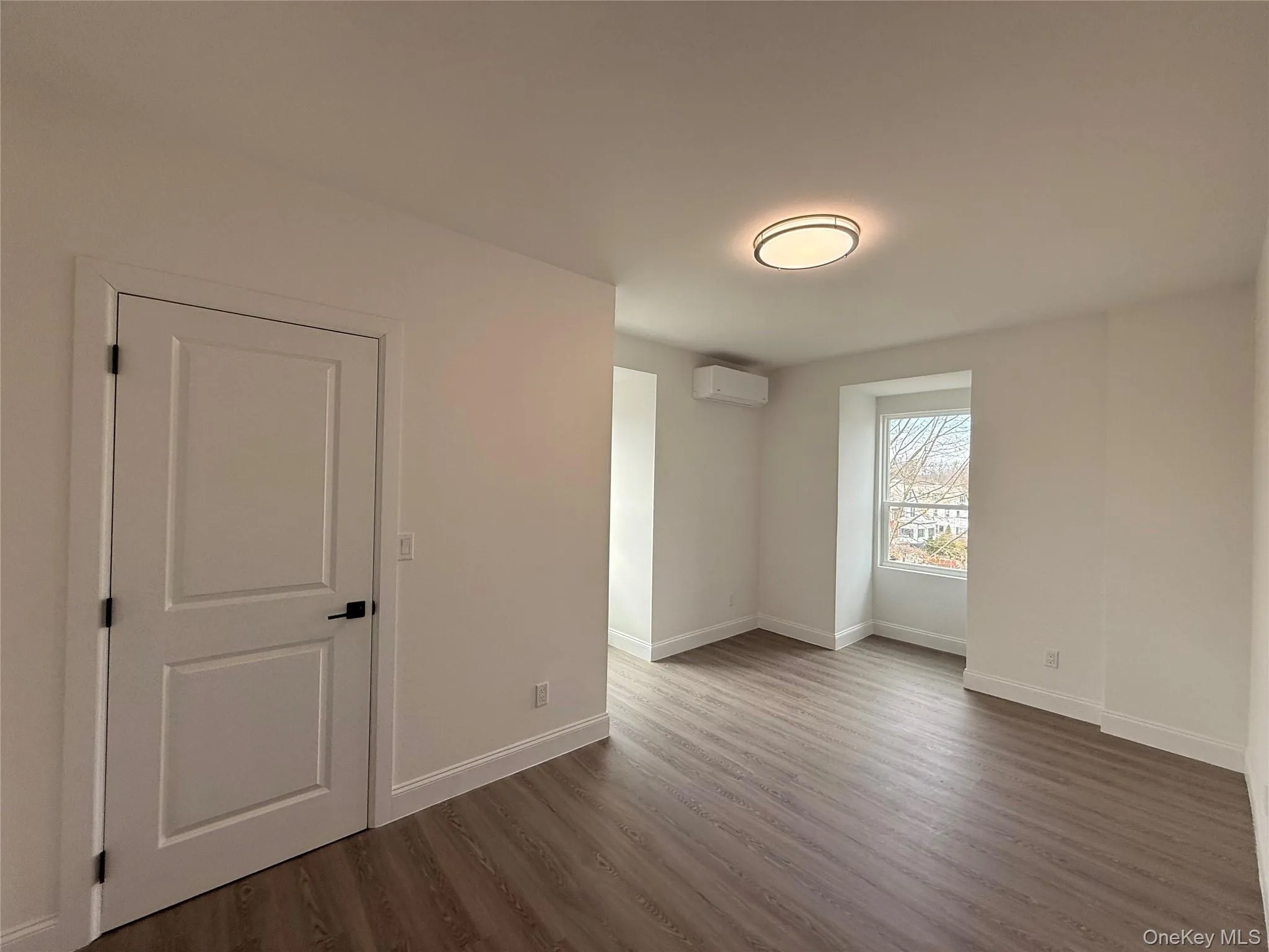 Bedroom #2 with dark wood-style floors and a mini split for heating / cooling Bedroom #2 with dark wood-style floors and a mini split for heating / cooling