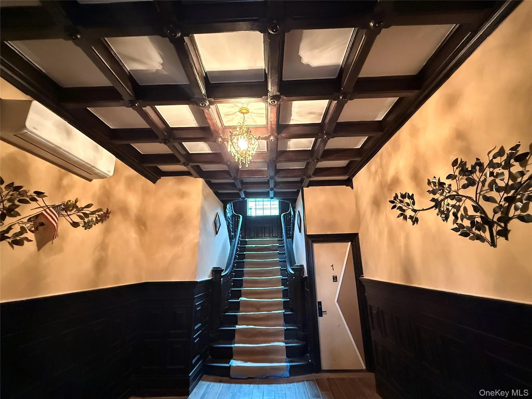 Staircase with coffered ceiling, a wainscoted wall, wood finished floors, and wooden walls Staircase with coffered ceiling, a wainscoted wall, wood finished floors, and wooden walls