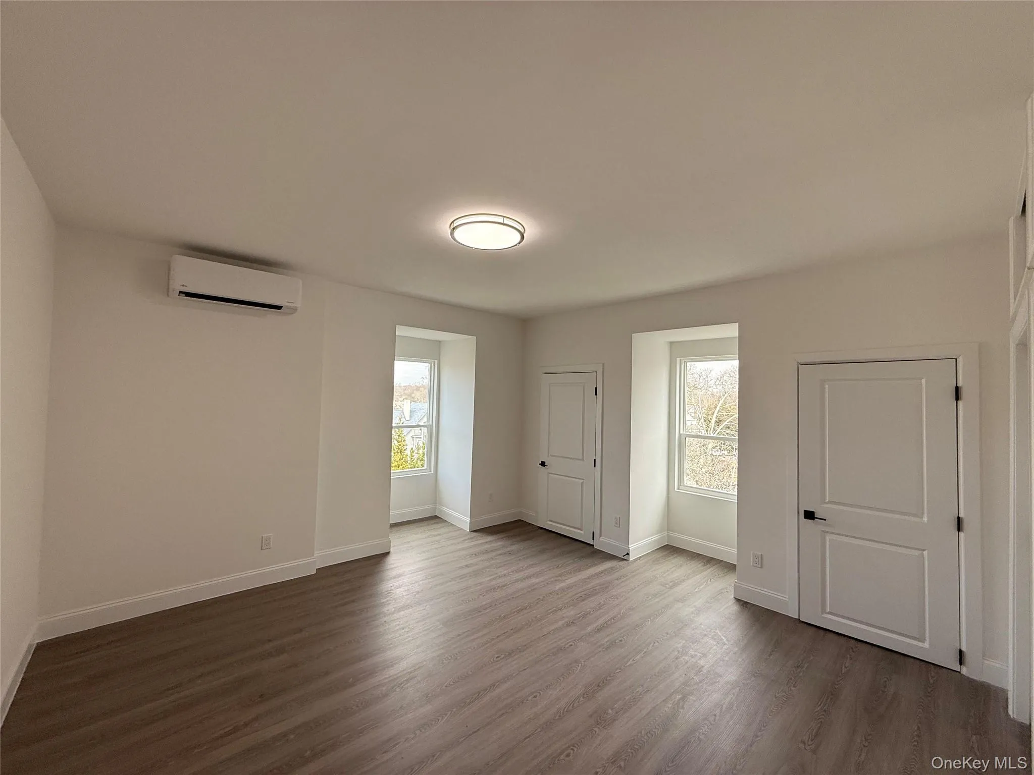Bedroom #4 featuring dark wood-style floors and multiple windows Bedroom #4 featuring dark wood-style floors and multiple windows