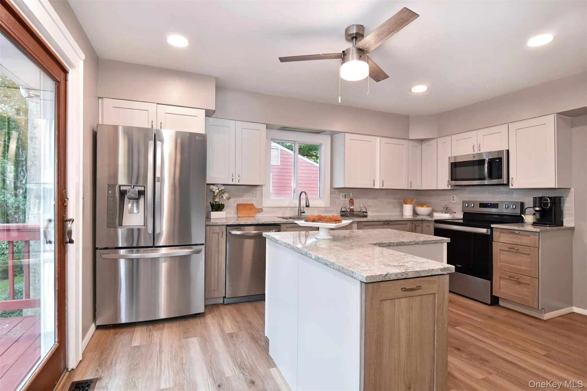 Light floods the kitchen from a wall of windows, and sliding glass doors. Light floods the kitchen from a wall of windows, and sliding glass doors.
