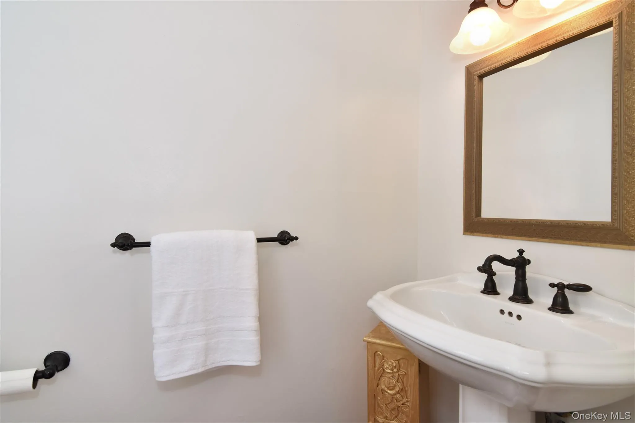 The adjacent half bath has a timeless aesthetic. The adjacent half bath has a timeless aesthetic.