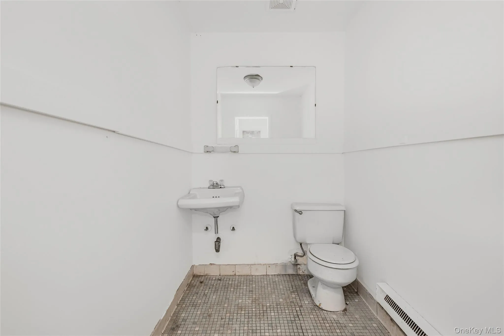 Bathroom featuring a baseboard heating unit, baseboards, toilet, and tile patterned floors Bathroom featuring a baseboard heating unit, baseboards, toilet, and tile patterned floors