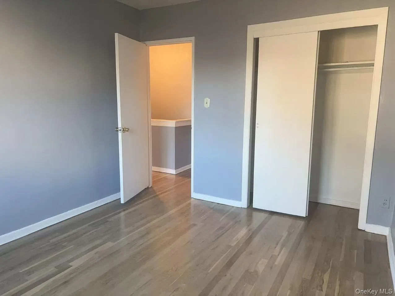 Unfurnished bedroom with dark wood-style flooring and a closet Unfurnished bedroom with dark wood-style flooring and a closet