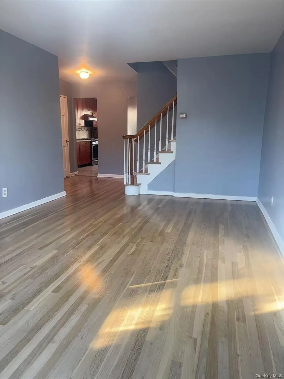Unfurnished living room with light wood-style floors and stairs Unfurnished living room with light wood-style floors and stairs