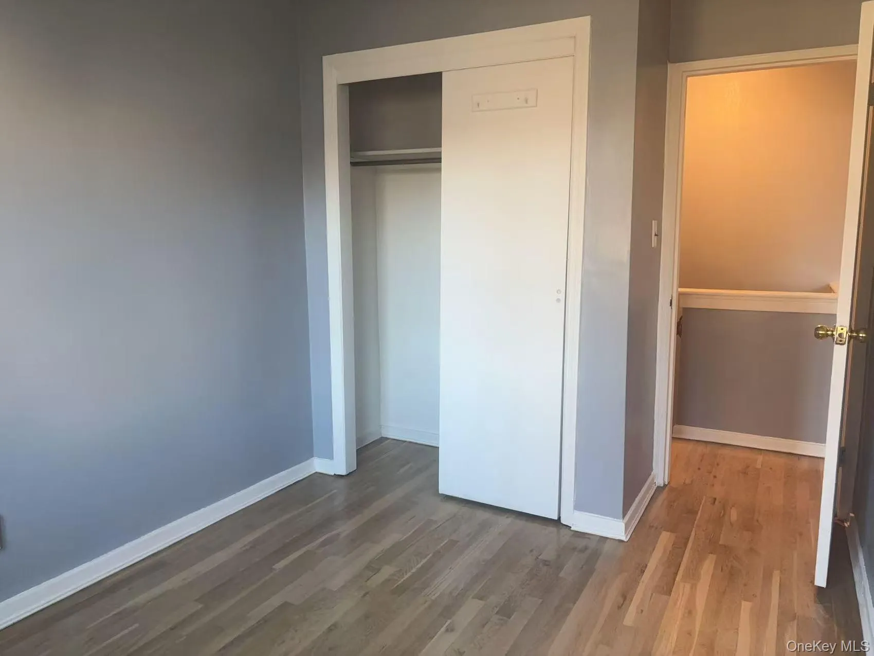 Unfurnished bedroom with a closet and wood finished floors Unfurnished bedroom with a closet and wood finished floors