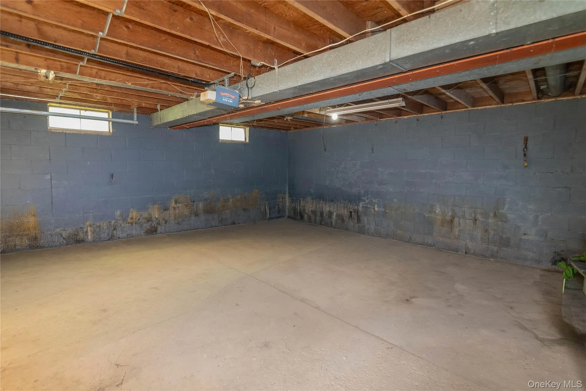 Unfinished basement space featuring exposed wood joists and concrete flooring Unfinished basement space featuring exposed wood joists and concrete flooring