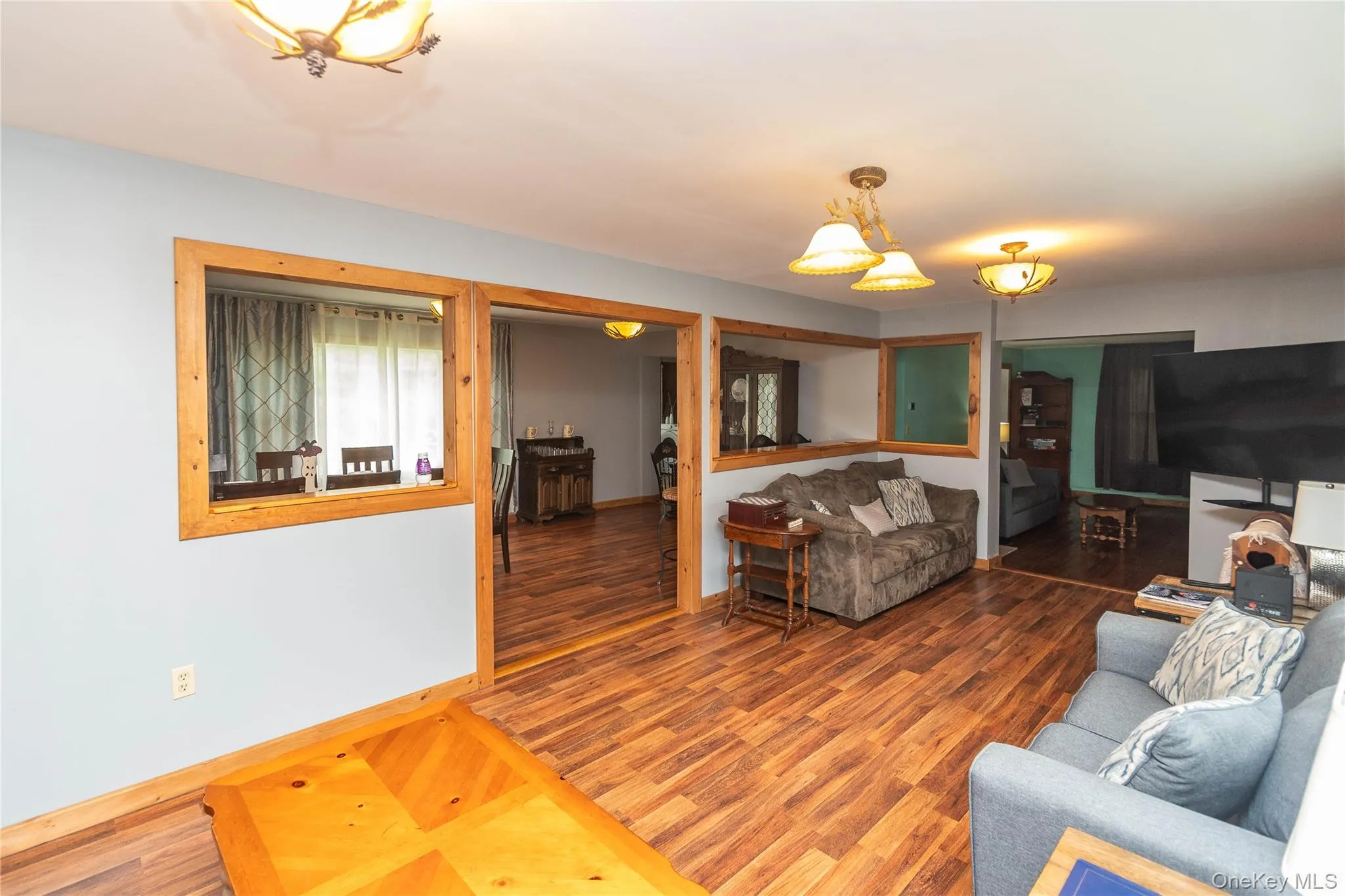 Living area featuring wood-finish flooring, light blue wall paint, and natural wood trim throughout Living area featuring wood-finish flooring, light blue wall paint, and natural wood trim throughout