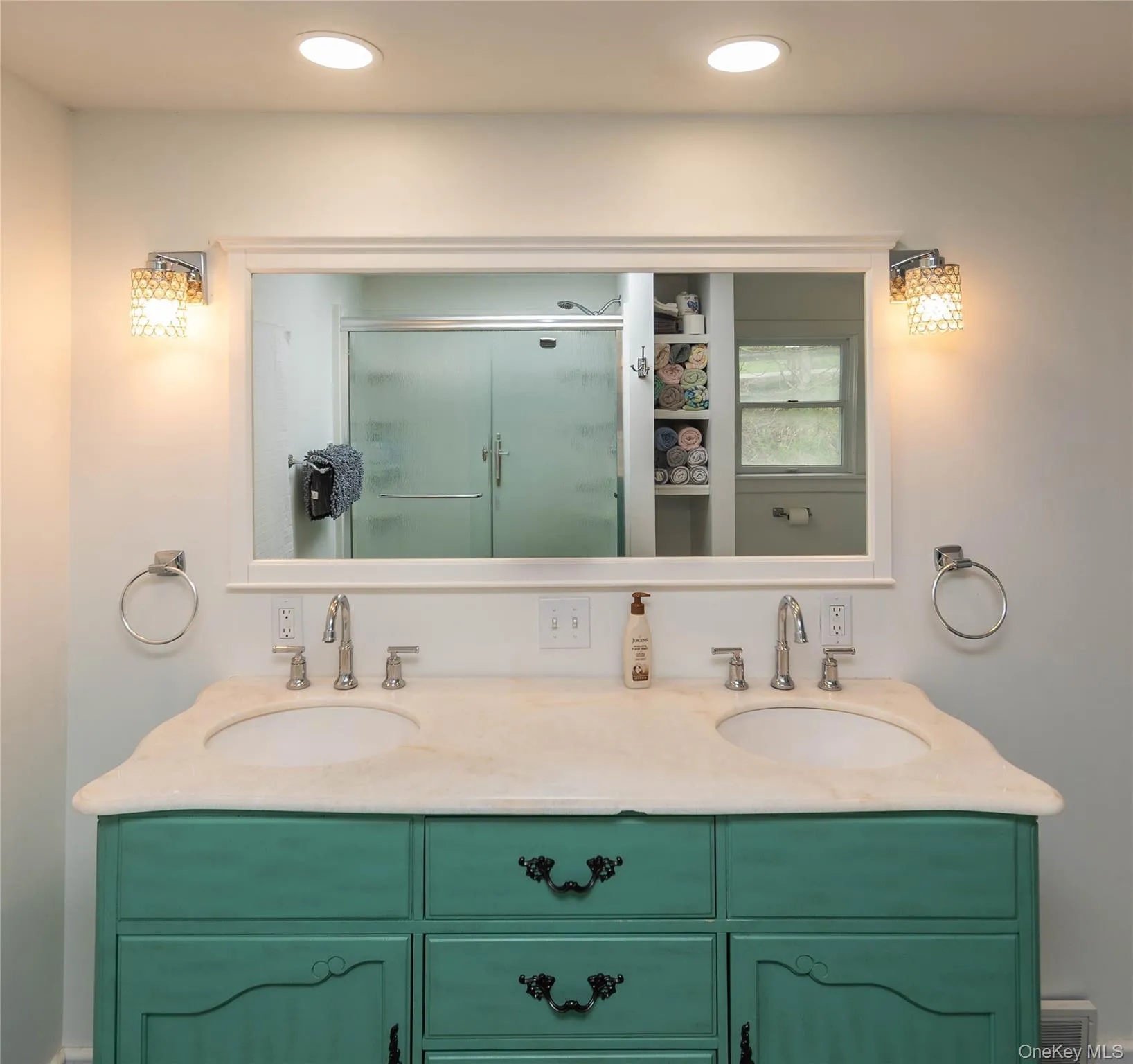 Dual vanity featuring a custom teal finish, stone countertop, and two integrated sinks Dual vanity featuring a custom teal finish, stone countertop, and two integrated sinks