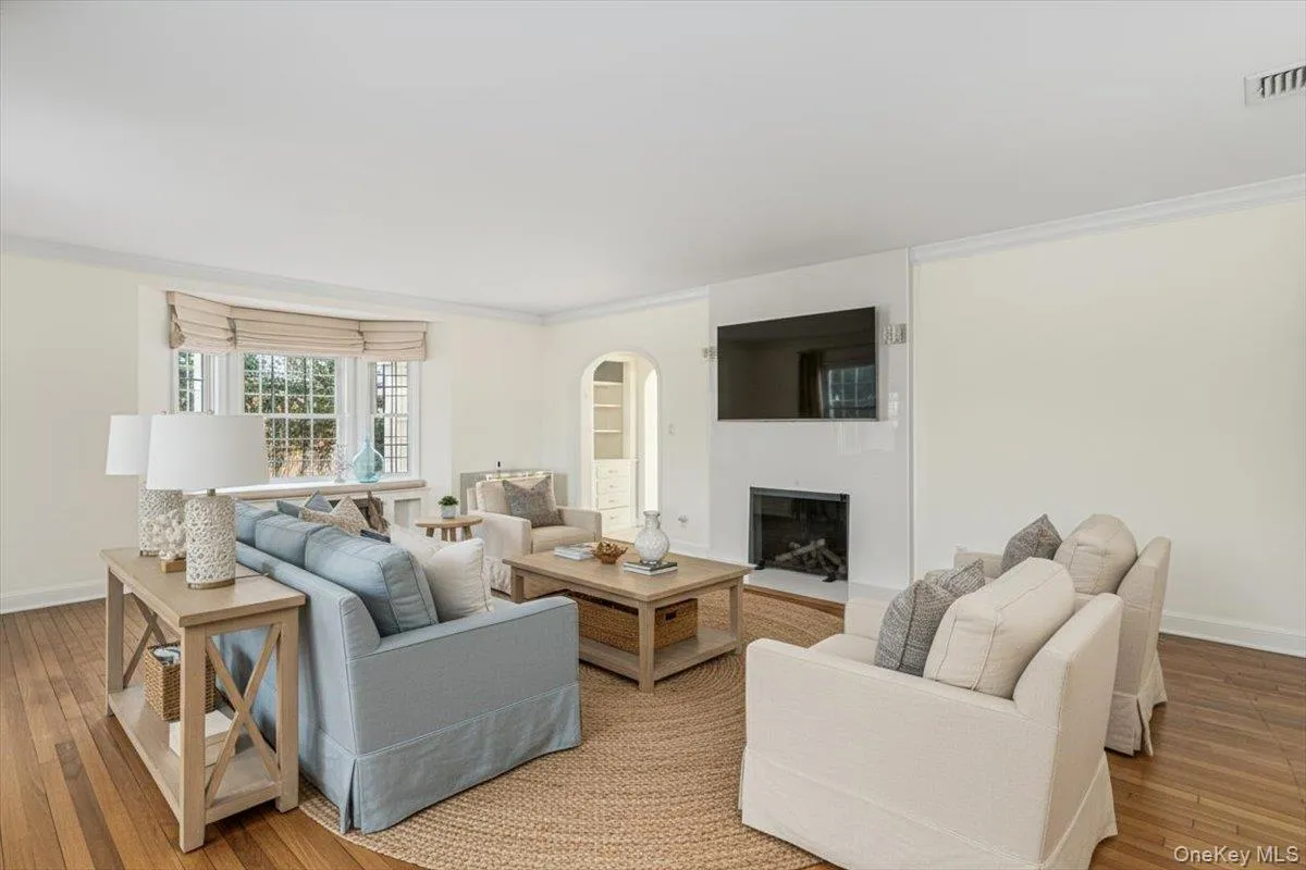 The Staged Living Room features hardwood flooring, a wood burning fireplace, charming window seat and arched doorways. The Staged Living Room features hardwood flooring, a wood burning fireplace, charming window seat and arched doorways.