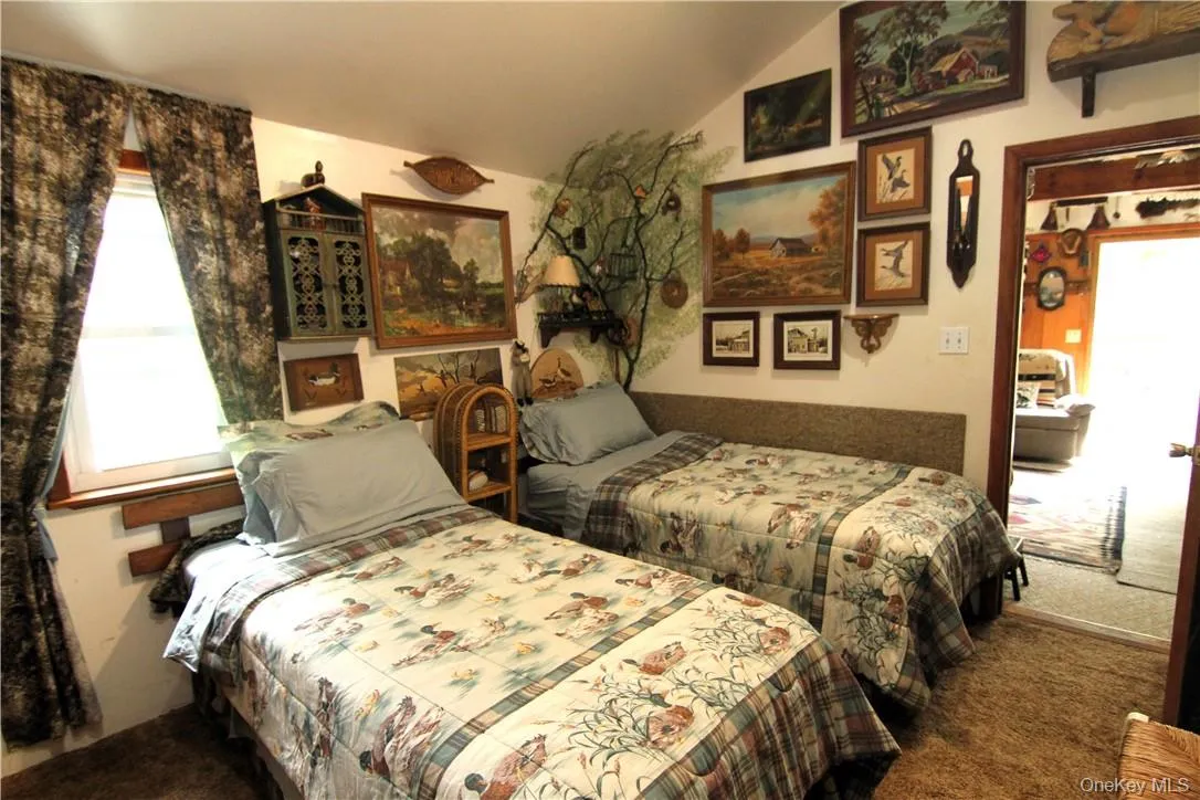 Bedroom featuring carpet floors and vaulted ceiling Bedroom featuring carpet floors and vaulted ceiling
