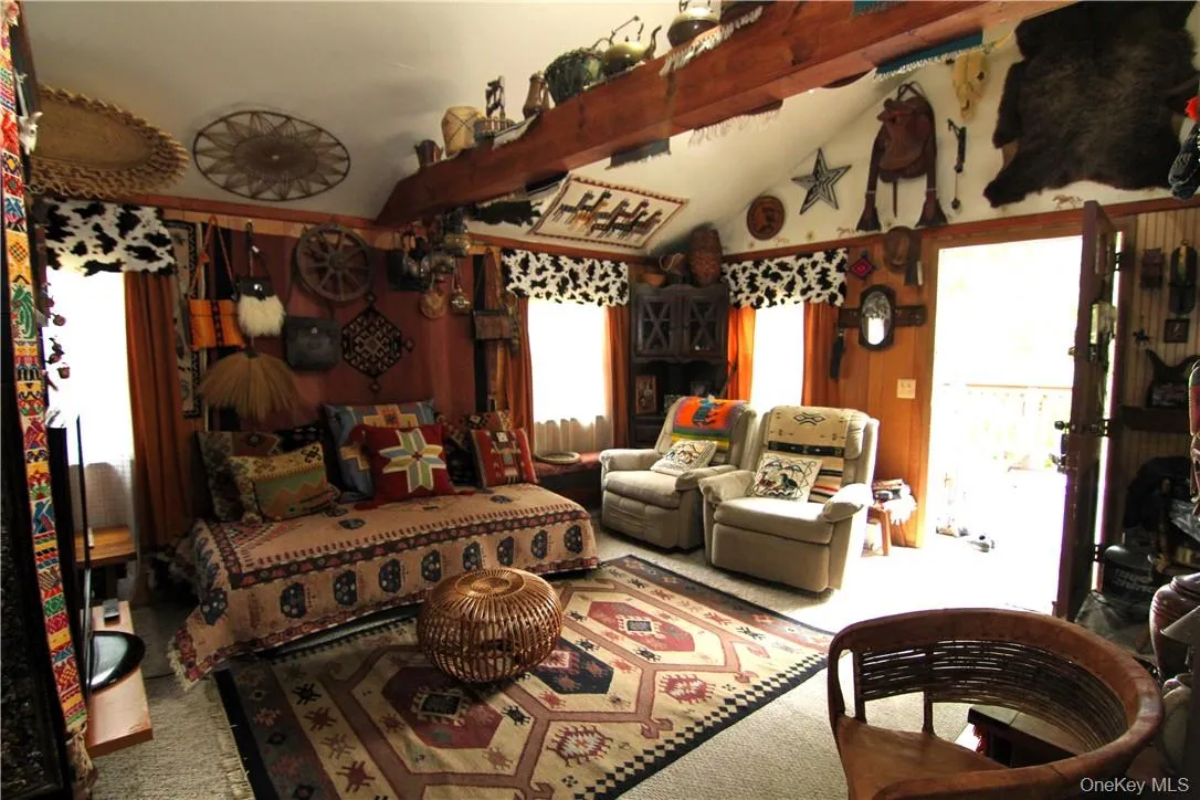Living room with carpet and vaulted ceiling with beams Living room with carpet and vaulted ceiling with beams