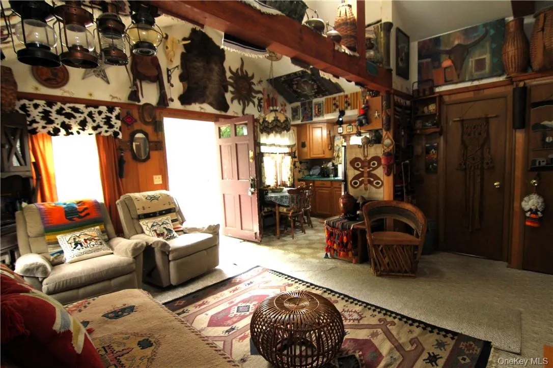 Living room featuring high vaulted ceiling, beamed ceiling, and carpet floors Living room featuring high vaulted ceiling, beamed ceiling, and carpet floors