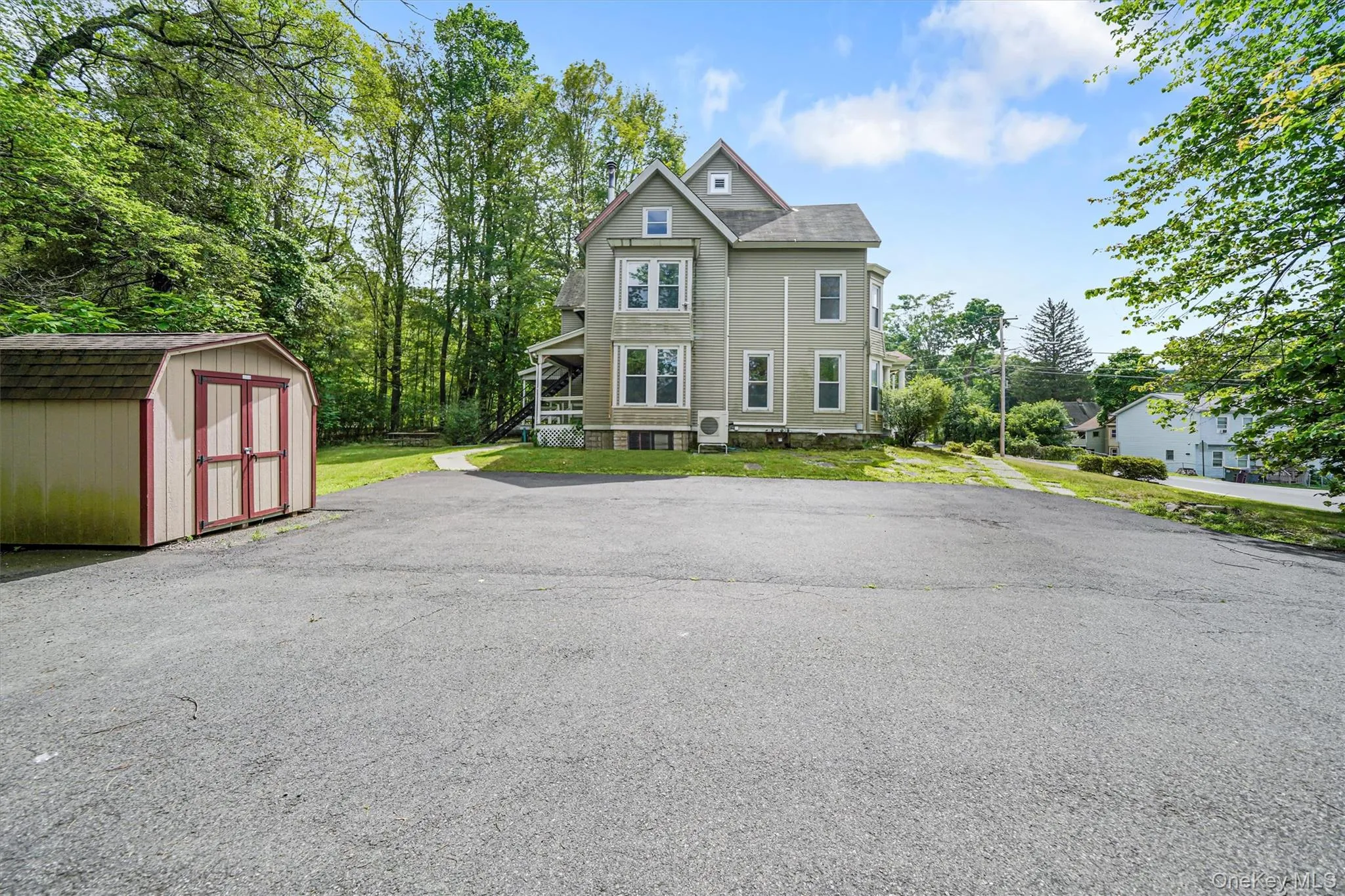 Victorian-style house with a storage shed and a front lawn Victorian-style house with a storage shed and a front lawn