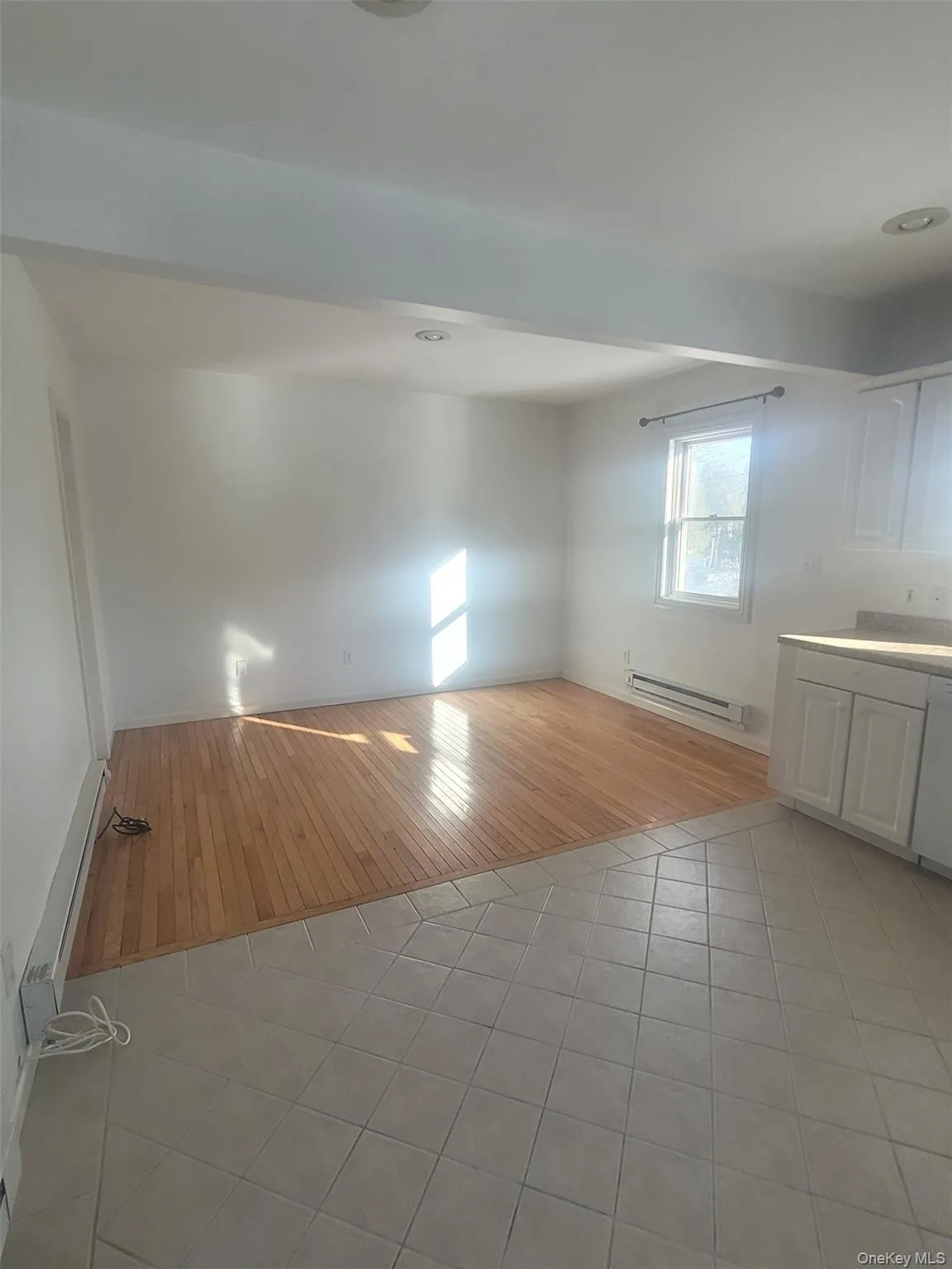 Another view of the living room with hardwood floors and tiled kitchen floors Another view of the living room with hardwood floors and tiled kitchen floors