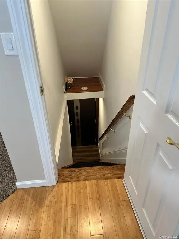 Staircase featuring hardwood / wood-style floors and baseboards Staircase featuring hardwood / wood-style floors and baseboards