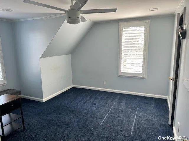 Additional living space featuring lofted ceiling, carpet floors, a ceiling fan, and baseboards Additional living space featuring lofted ceiling, carpet floors, a ceiling fan, and baseboards