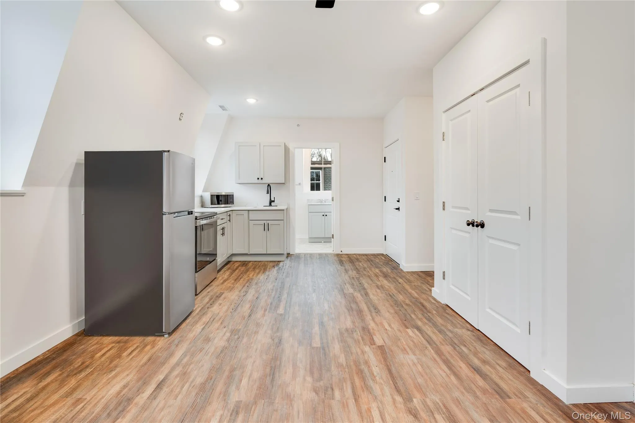 Kitchen with sink, hardwood / wood-style flooring, and appliances with stainless steel finishes Kitchen with sink, hardwood / wood-style flooring, and appliances with stainless steel finishes