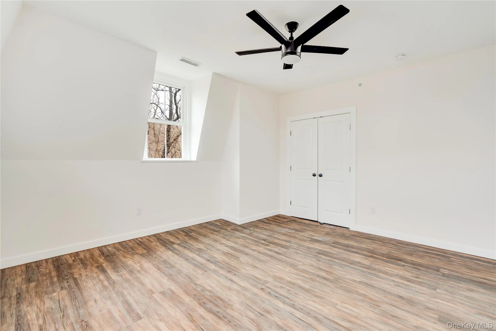 Spare room with wood-type flooring and ceiling fan Spare room with wood-type flooring and ceiling fan