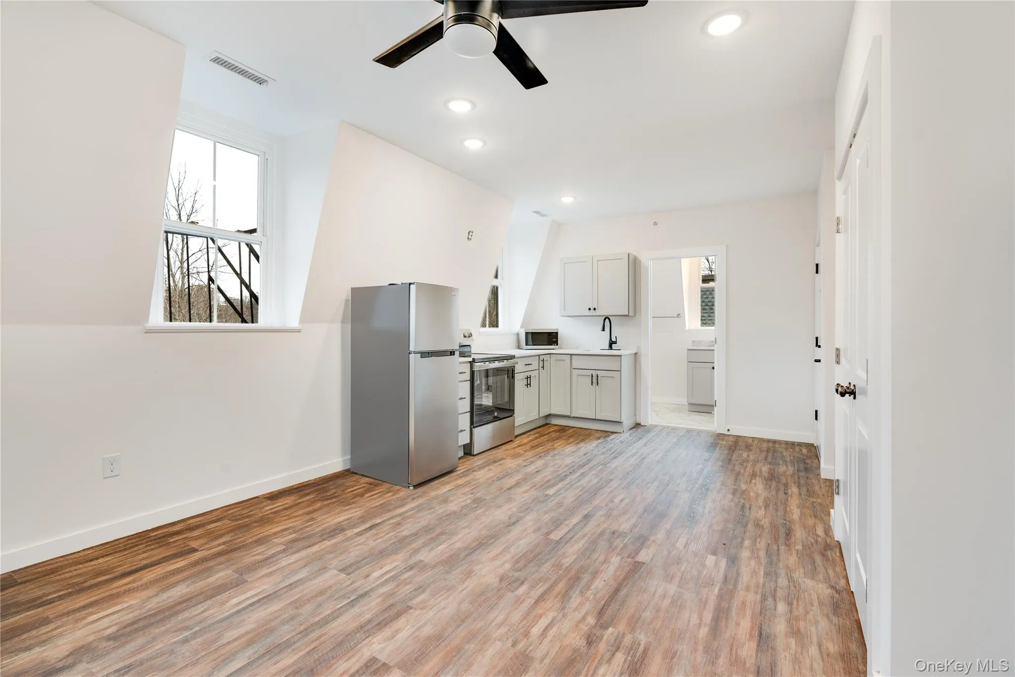 Kitchen with sink, stainless steel appliances, plenty of natural light, and hardwood / wood-style flooring Kitchen with sink, stainless steel appliances, plenty of natural light, and hardwood / wood-style flooring