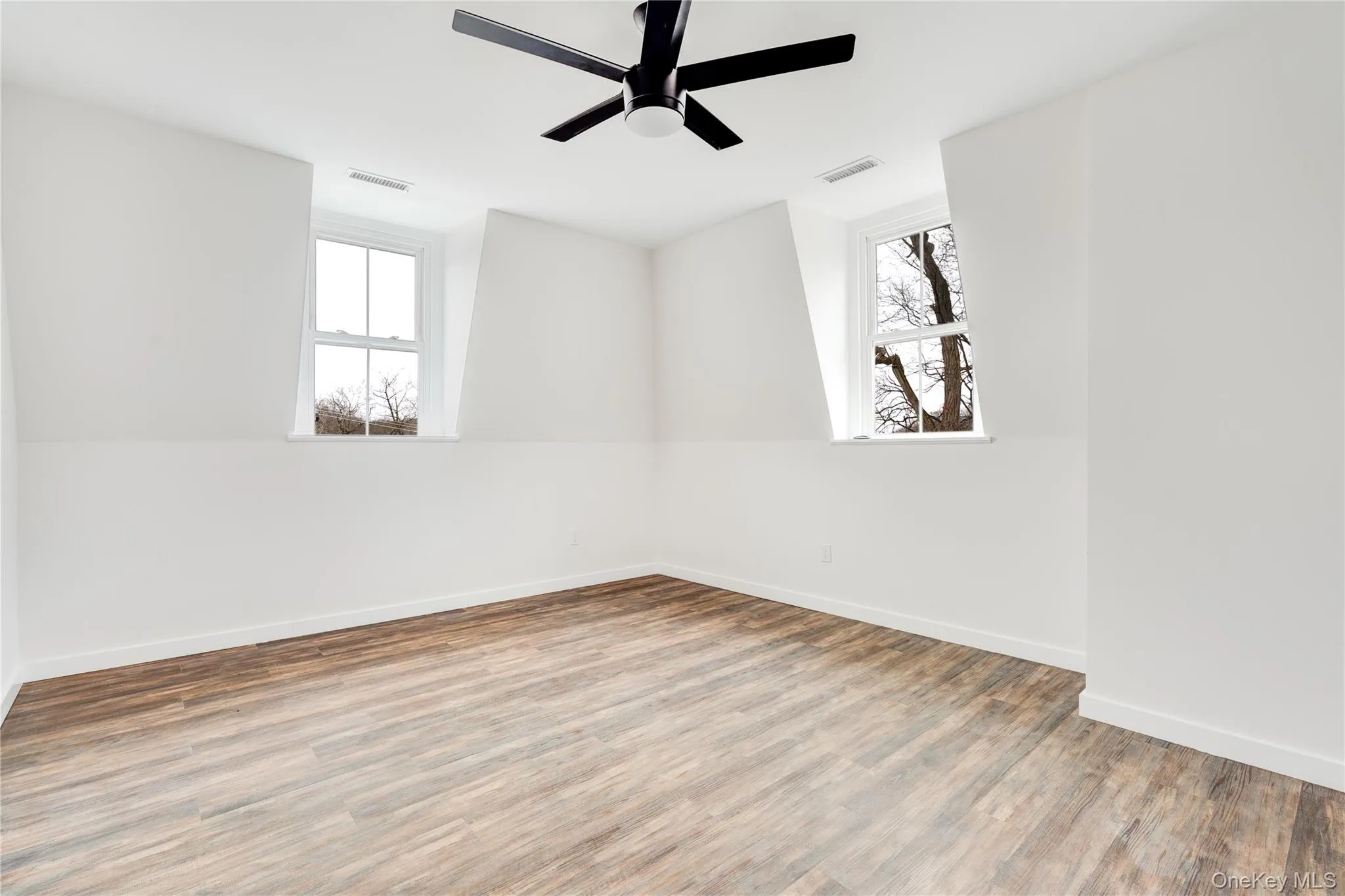 Unfurnished room featuring wood-type flooring and ceiling fan Unfurnished room featuring wood-type flooring and ceiling fan