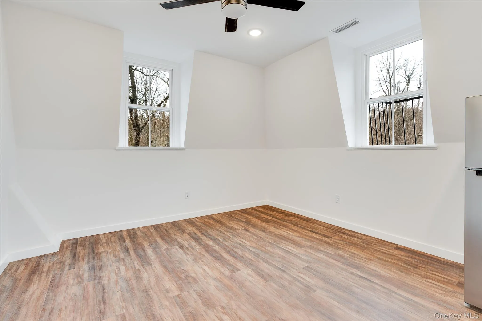 Spare room featuring wood-type flooring and ceiling fan Spare room featuring wood-type flooring and ceiling fan