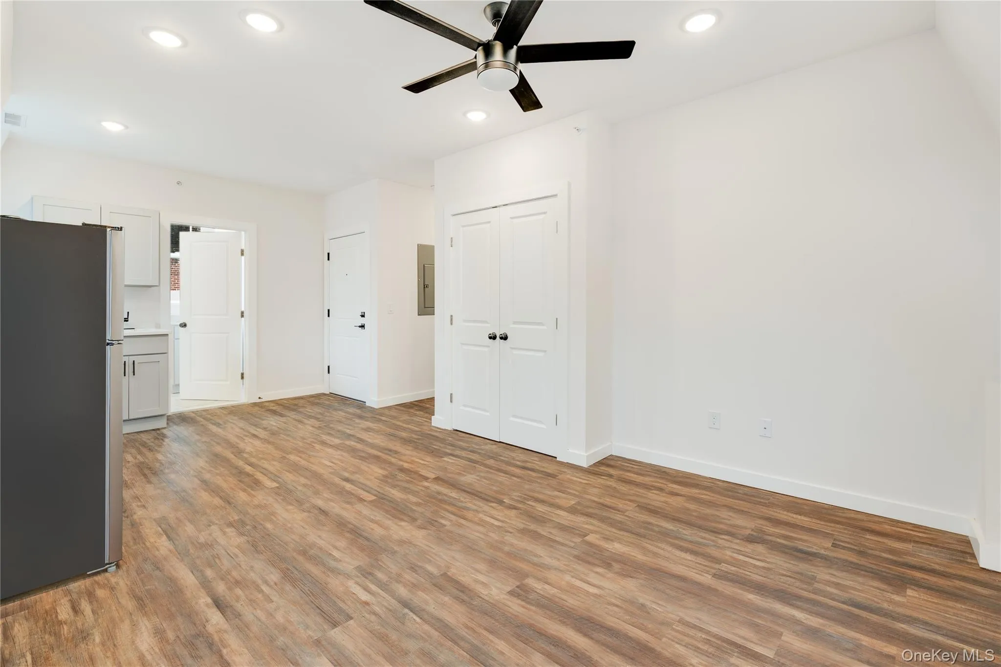 Unfurnished living room with ceiling fan and hardwood / wood-style floors Unfurnished living room with ceiling fan and hardwood / wood-style floors