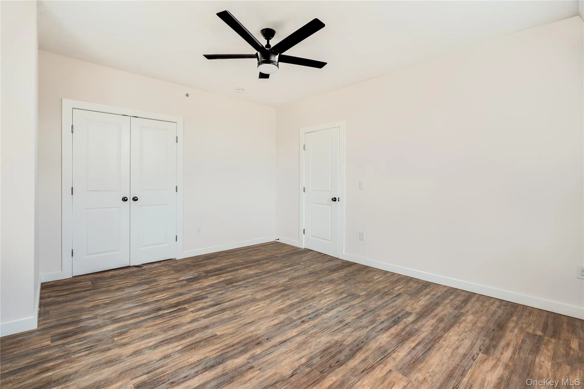 Unfurnished bedroom featuring a closet, ceiling fan, and dark hardwood / wood-style flooring Unfurnished bedroom featuring a closet, ceiling fan, and dark hardwood / wood-style flooring