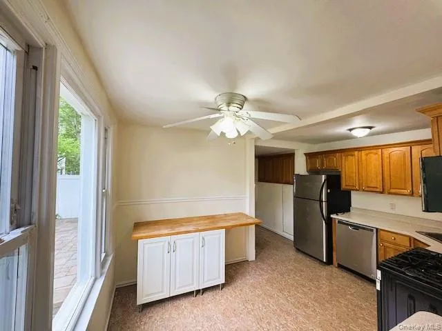 Kitchen featuring wood-finish cabinetry, Butcher Block, Stainless Steel Appliances and ceiling fan Kitchen featuring wood-finish cabinetry, Butcher Block, Stainless Steel Appliances and ceiling fan