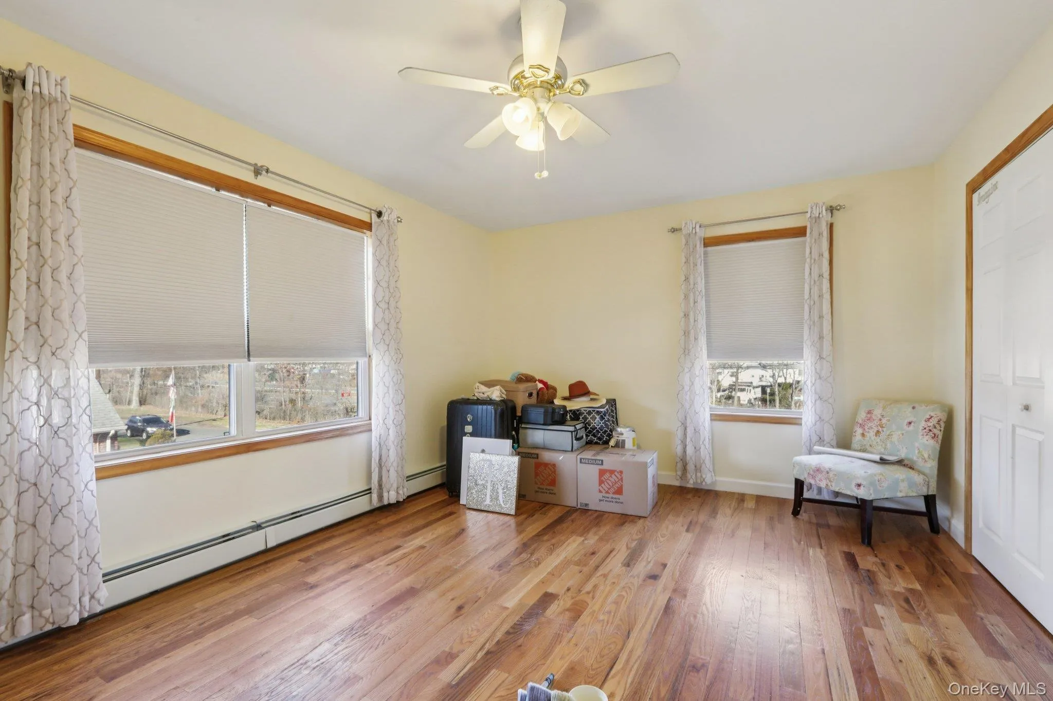Living area with light wood finished floors, baseboard heating, and ceiling fan Living area with light wood finished floors, baseboard heating, and ceiling fan
