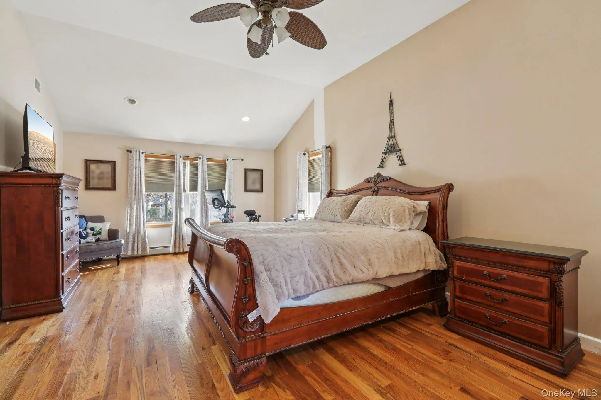 Bedroom with light wood-style floors, vaulted ceiling, and a ceiling fan Bedroom with light wood-style floors, vaulted ceiling, and a ceiling fan