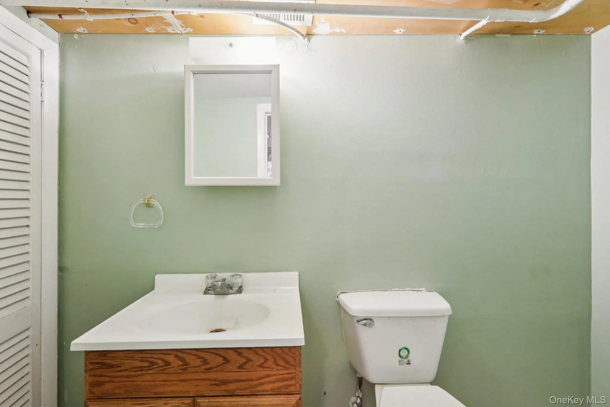 Half bath featuring a closet and vanity Half bath featuring a closet and vanity
