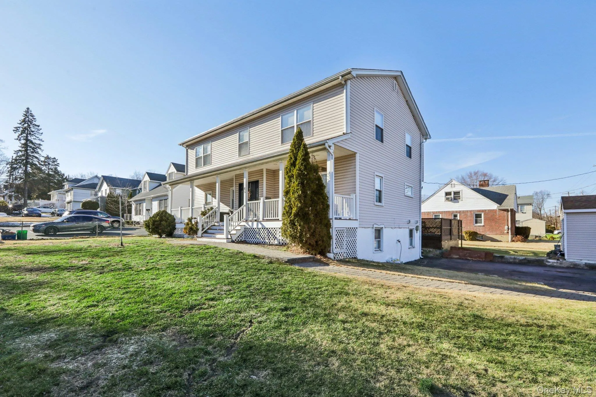 View of front of home featuring covered porch, a front yard, and a residential view View of front of home featuring covered porch, a front yard, and a residential view