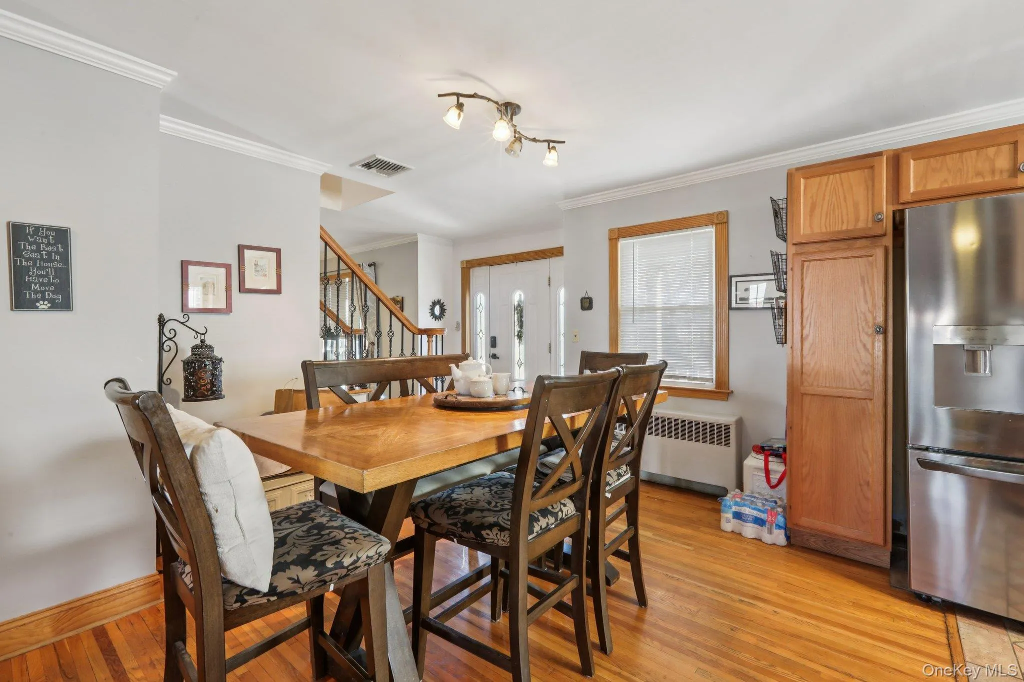 Dining area featuring light wood-style floors, radiator, and ornamental molding Dining area featuring light wood-style floors, radiator, and ornamental molding
