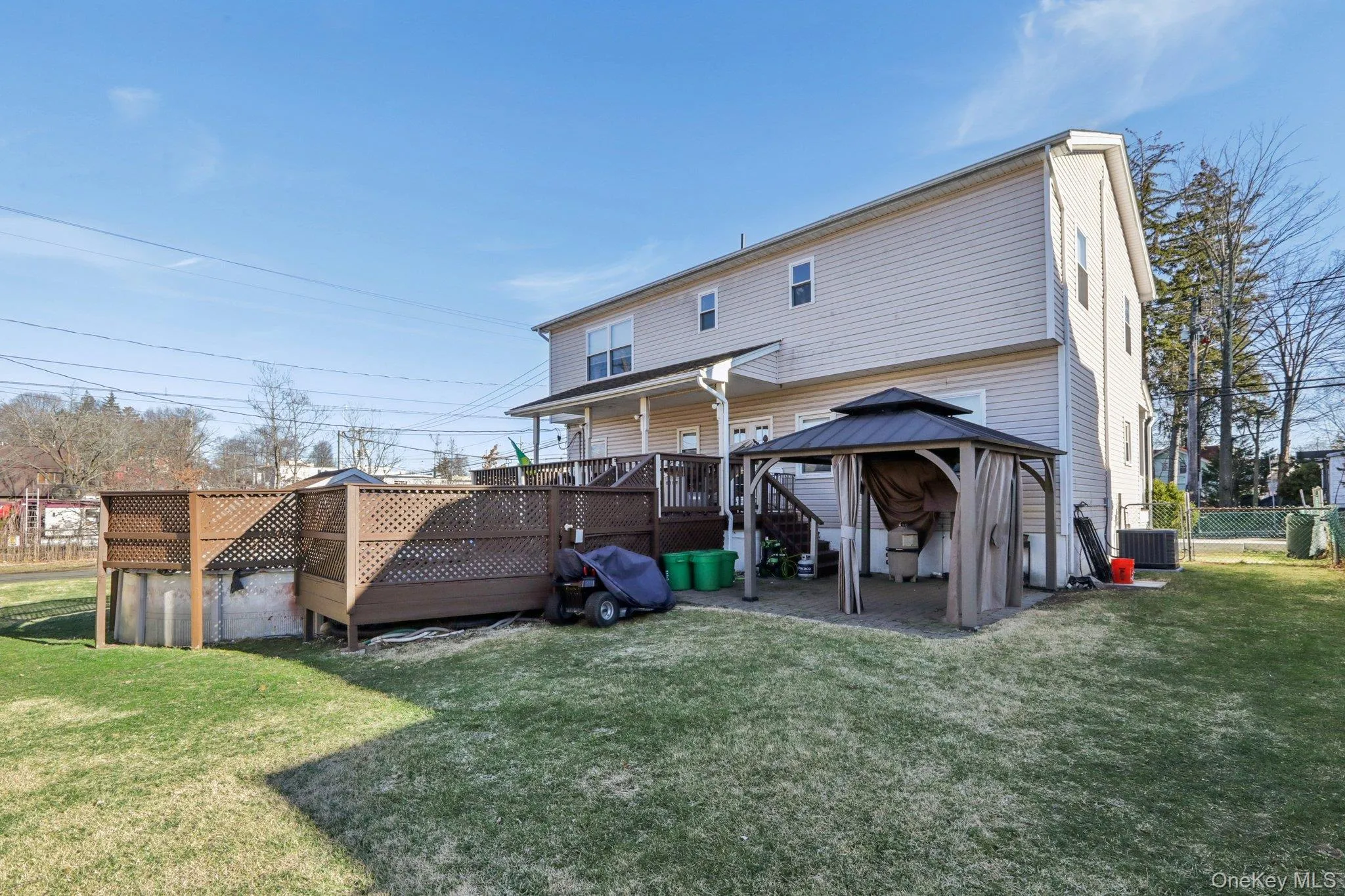 Back of property featuring a wooden deck, a gazebo, and a patio Back of property featuring a wooden deck, a gazebo, and a patio