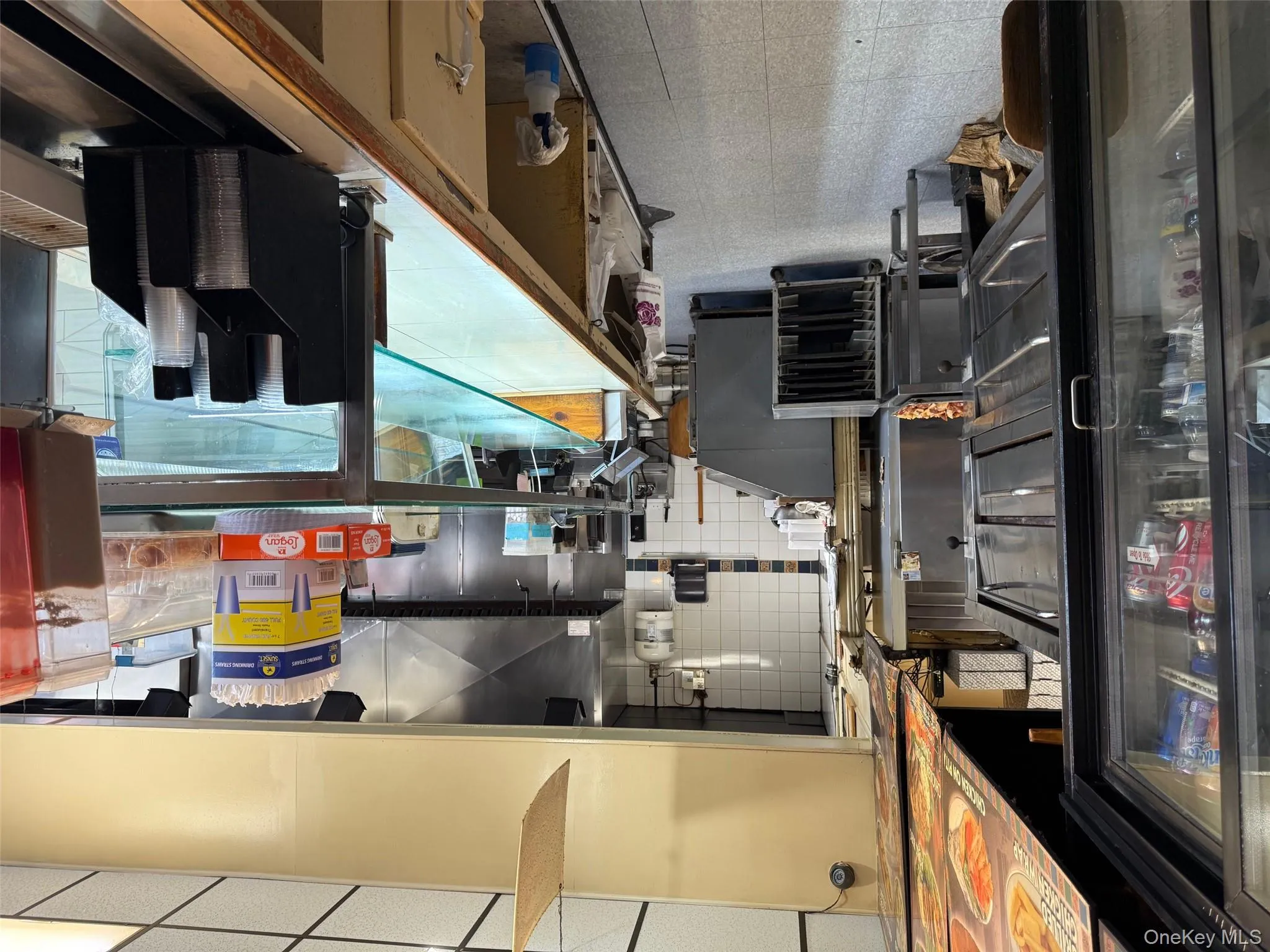 Kitchen with a drop ceiling, tile patterned floors, and tasteful backsplash Kitchen with a drop ceiling, tile patterned floors, and tasteful backsplash