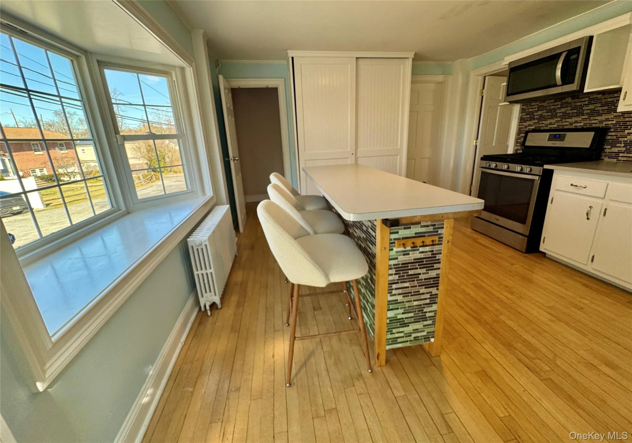 Kitchen with stainless steel appliances, island with stools, bay window seating Kitchen with stainless steel appliances, island with stools, bay window seating