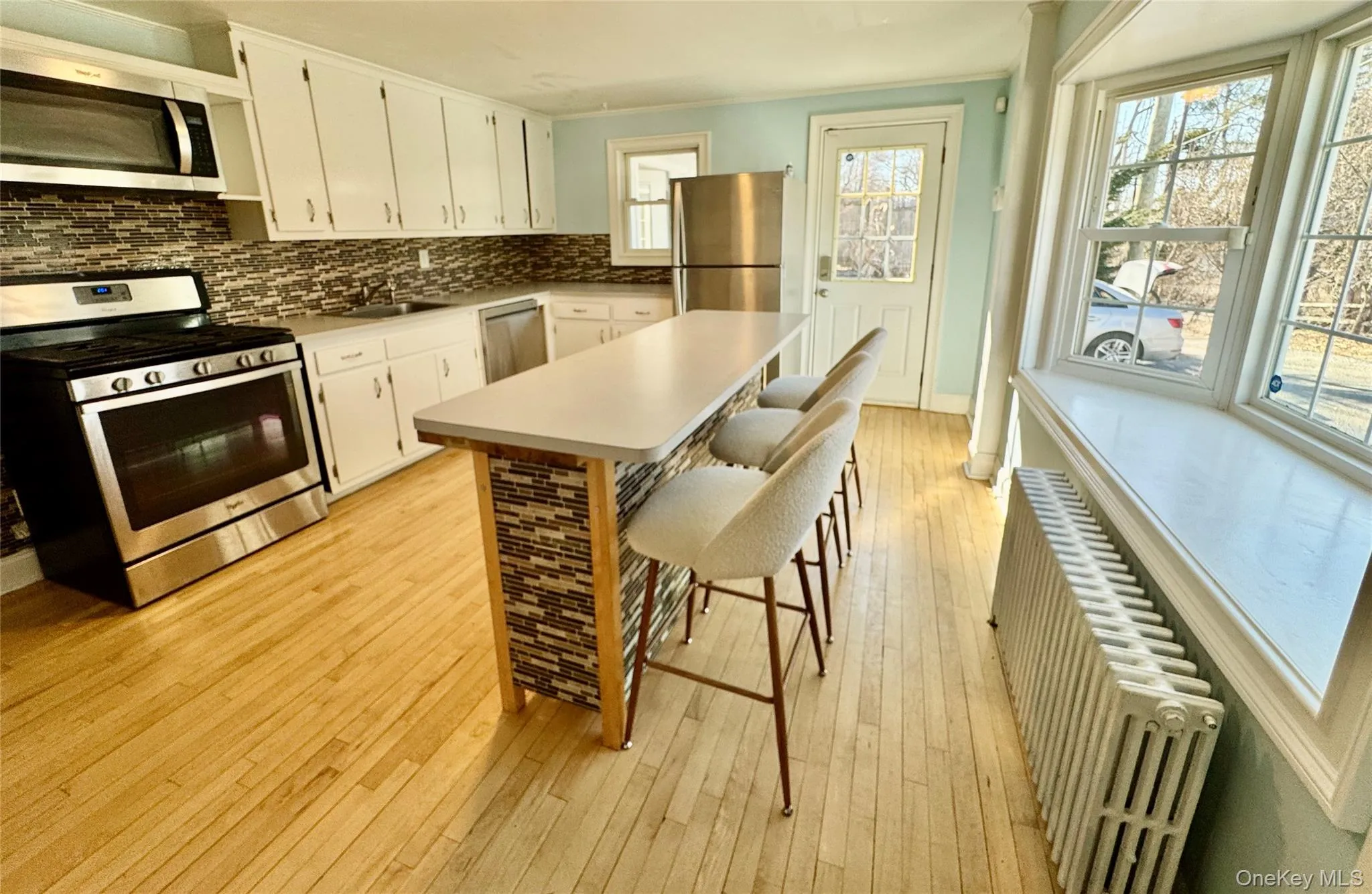Kitchen with stainless steel appliances, island with stools, bay window seating Kitchen with stainless steel appliances, island with stools, bay window seating