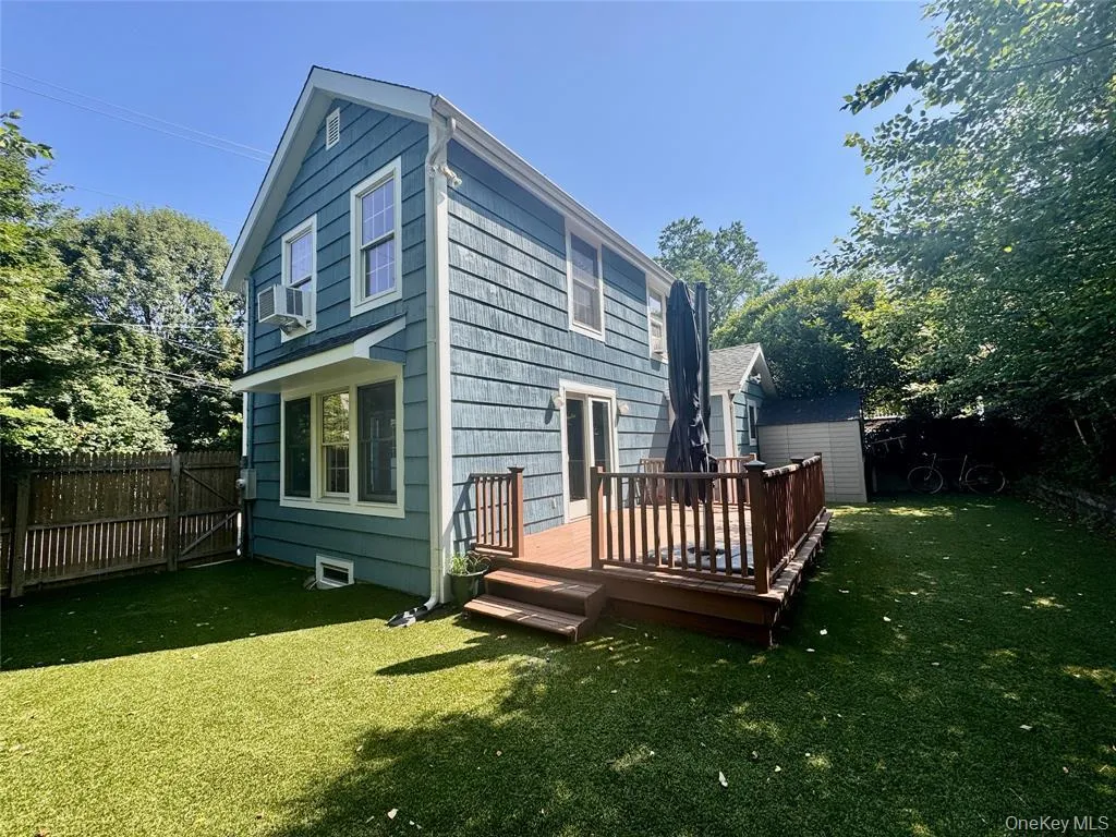 Rear view of house featuring a wooden deck, a fenced backyard, and a gate Rear view of house featuring a wooden deck, a fenced backyard, and a gate