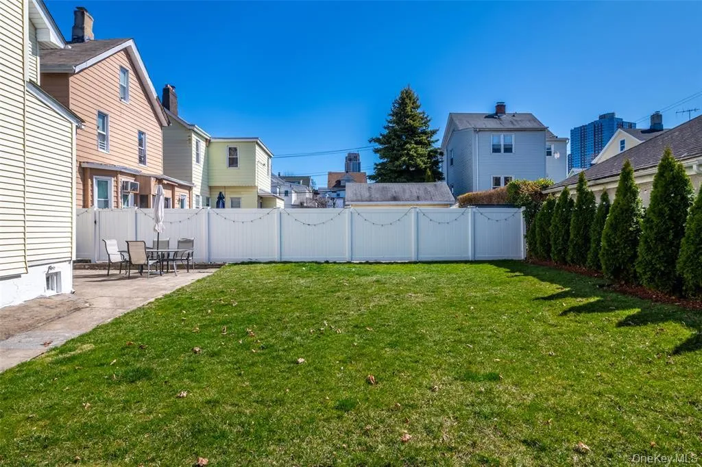 Fenced backyard featuring a patio area and a residential view Fenced backyard featuring a patio area and a residential view