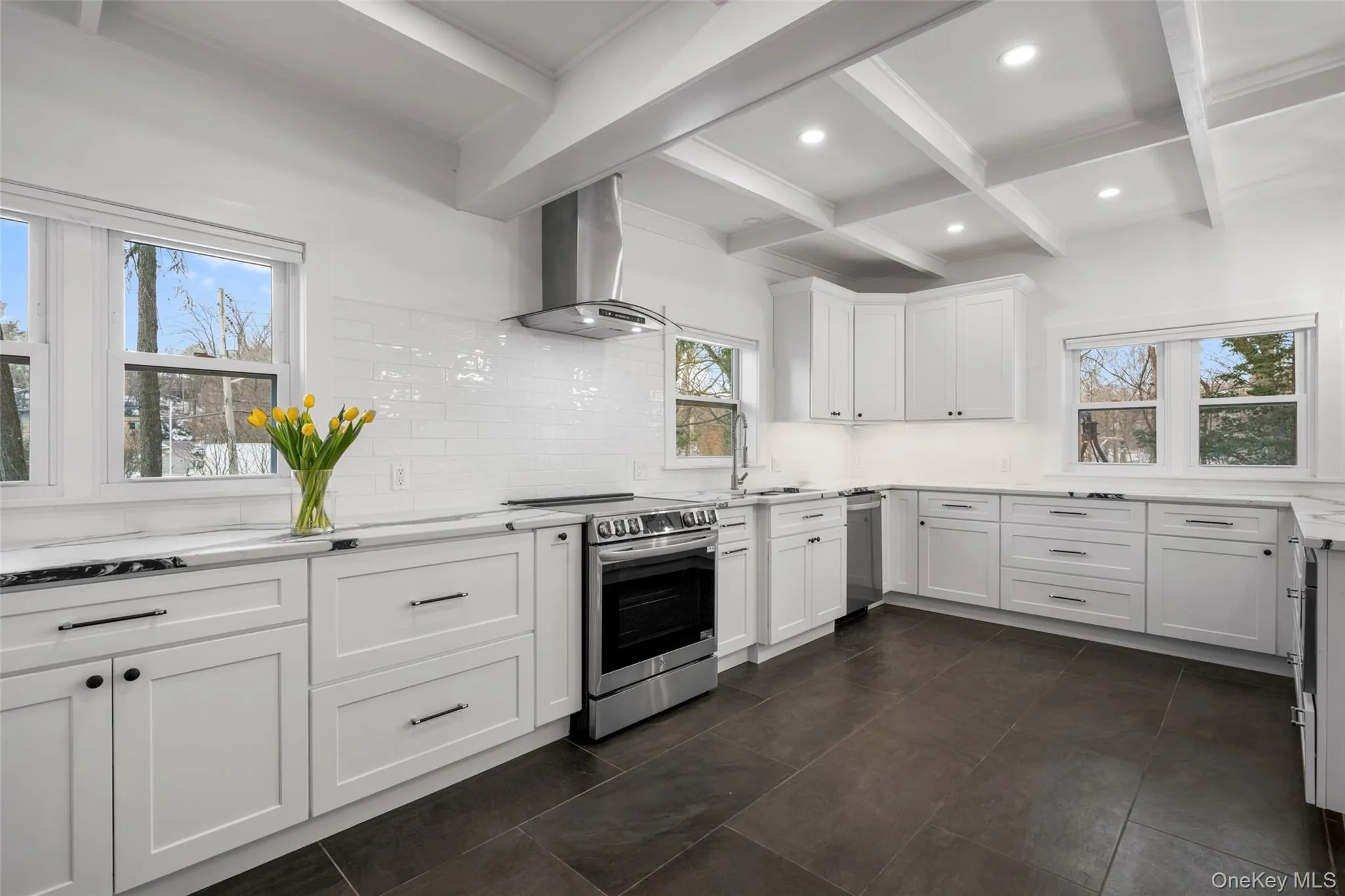 Sleek white cabinetry meets high-end stainless appliances and beautiful architectural ceiling details. Sleek white cabinetry meets high-end stainless appliances and beautiful architectural ceiling details.