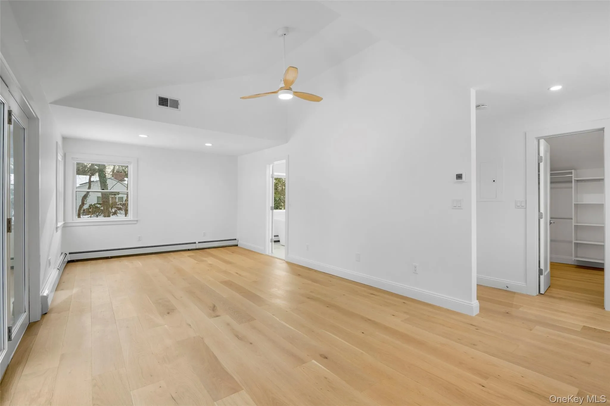 Spacious primary bedroom with a generous walk-in closet. Spacious primary bedroom with a generous walk-in closet.