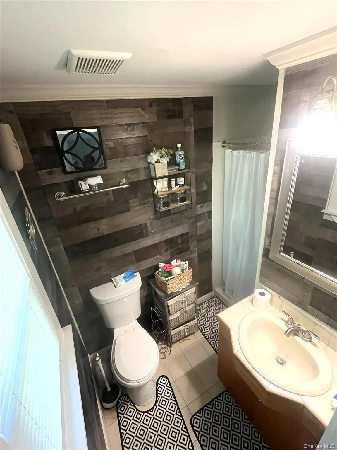 Master bathroom is nicely decorated with shiplap walls, tile floor full shower Master bathroom is nicely decorated with shiplap walls, tile floor full shower
