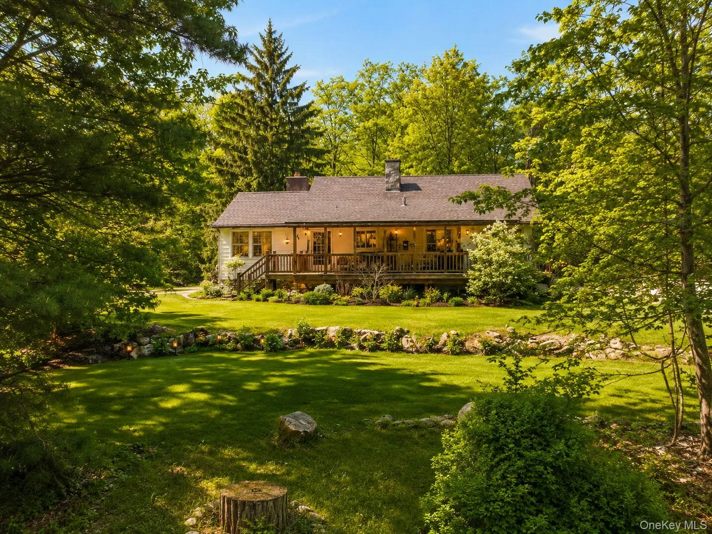 View of the back of the house with featuring a rock wall and back yard View of the back of the house with featuring a rock wall and back yard