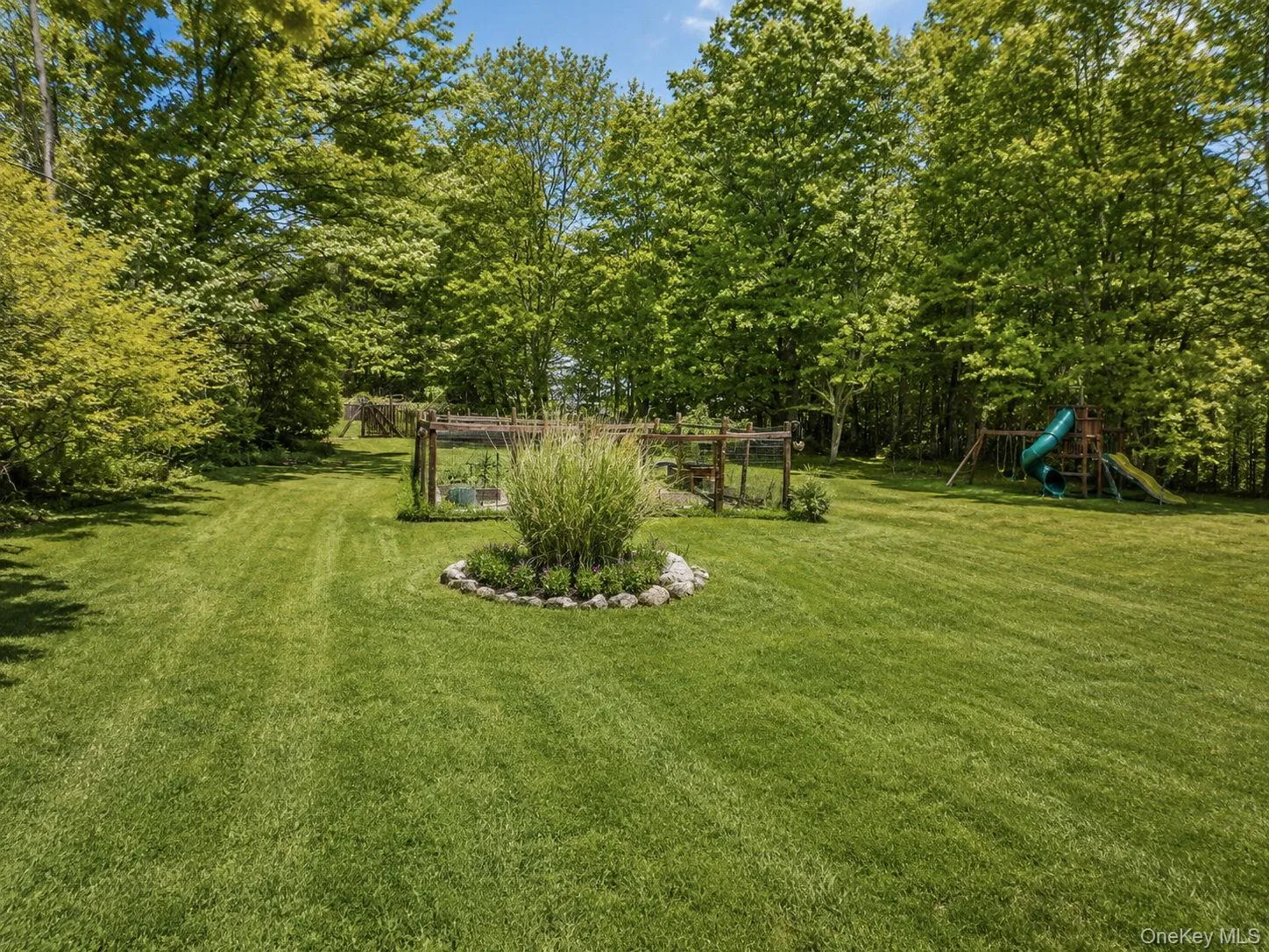Expansive green lawn surrounded by mature trees Expansive green lawn surrounded by mature trees