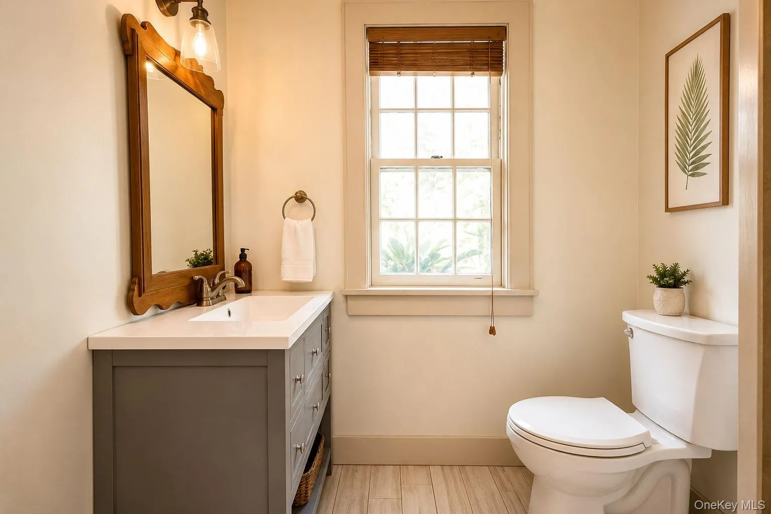 Bathroom featuring a gray vanity with a white countertop, a wood-framed mirror Bathroom featuring a gray vanity with a white countertop, a wood-framed mirror
